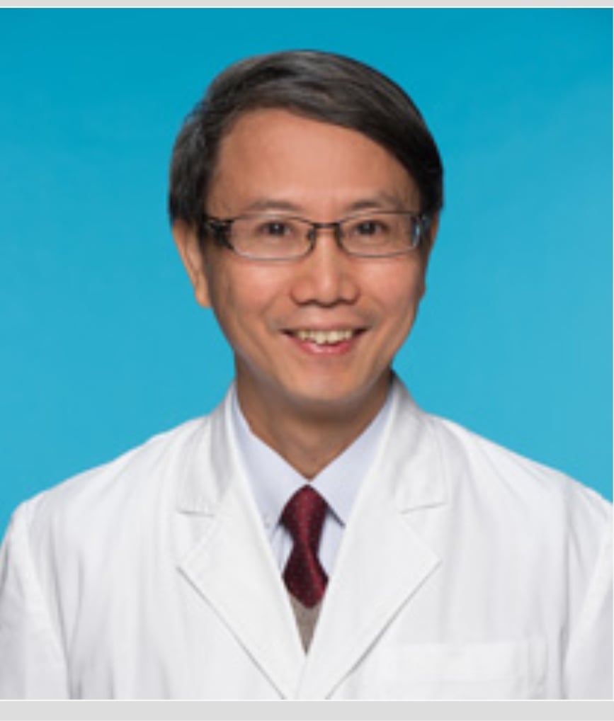 潘田成中醫師於香港浸會大學中醫藥學院臨床部入職照，佩戴醫師袍，專業形象照用於安德中醫診療中心簡介專欄。